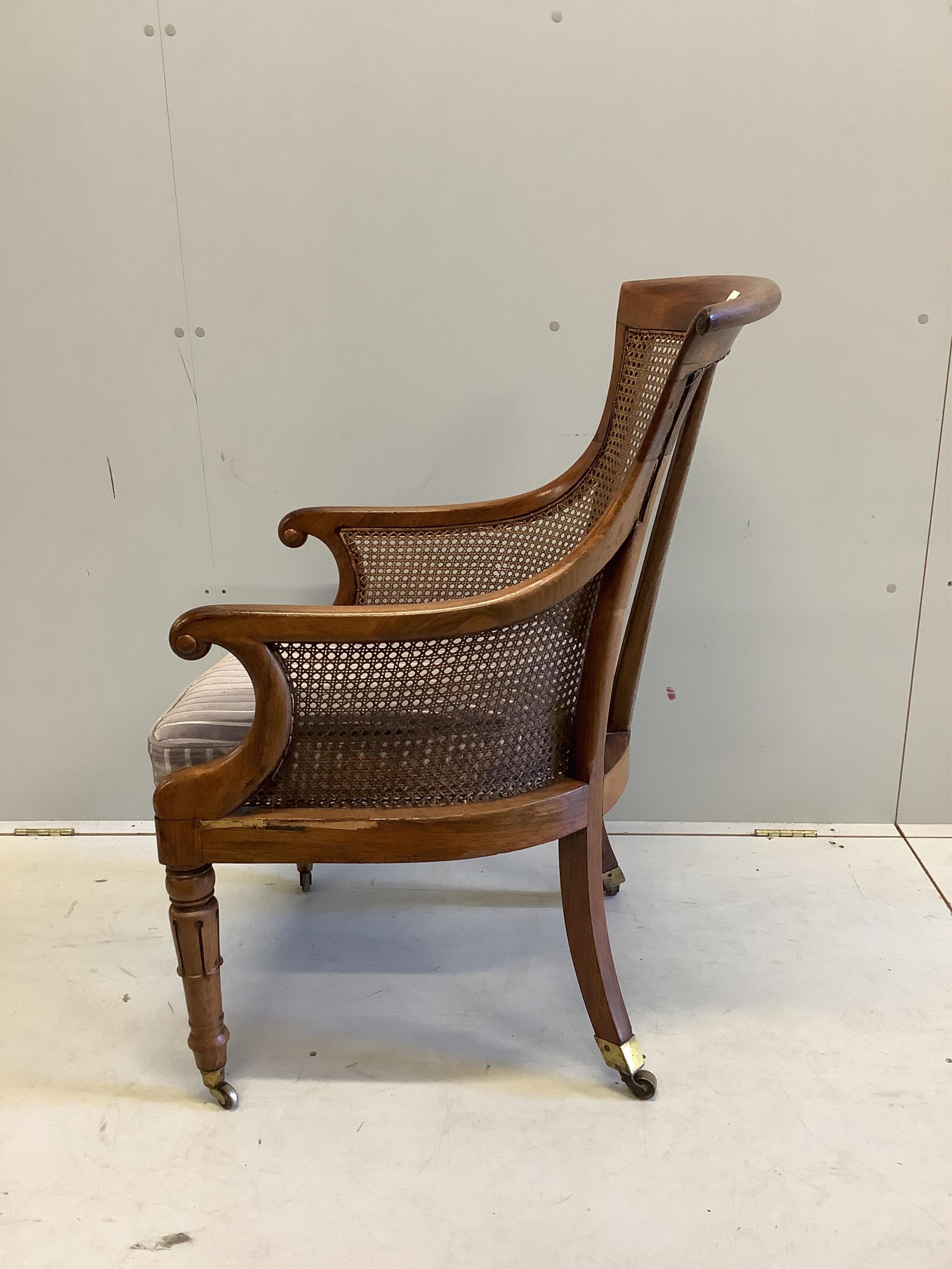 A William IV rosewood bergere library armchair, width 57cm, depth 74cm, height 98cm. Condition - fair, frame faded and has seen much restoration work with repairs to several areas, the cane is good.